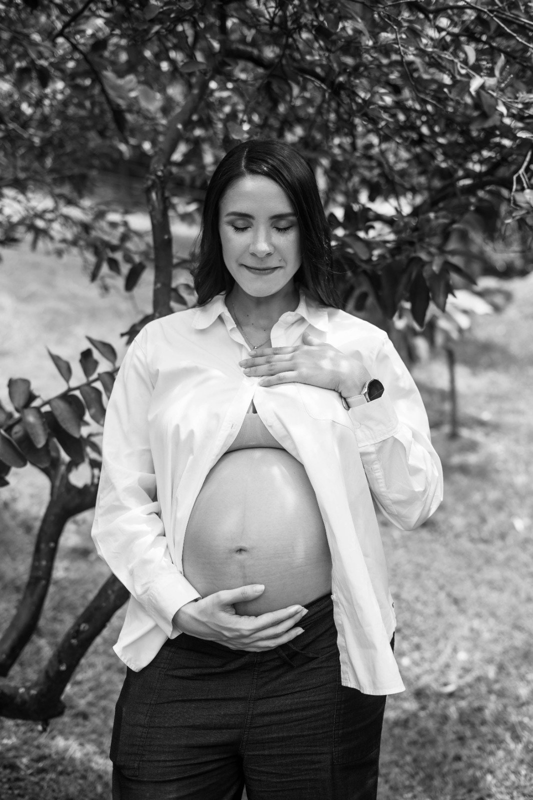Mujer embarazada en un momento de quietud bajo un árbol